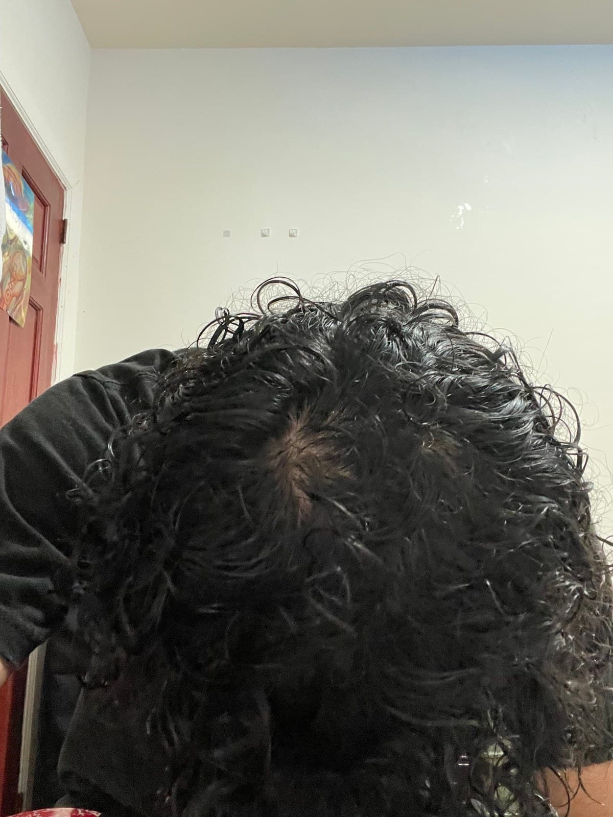 Head bent forward with wet curls parted, scalp visible during washing